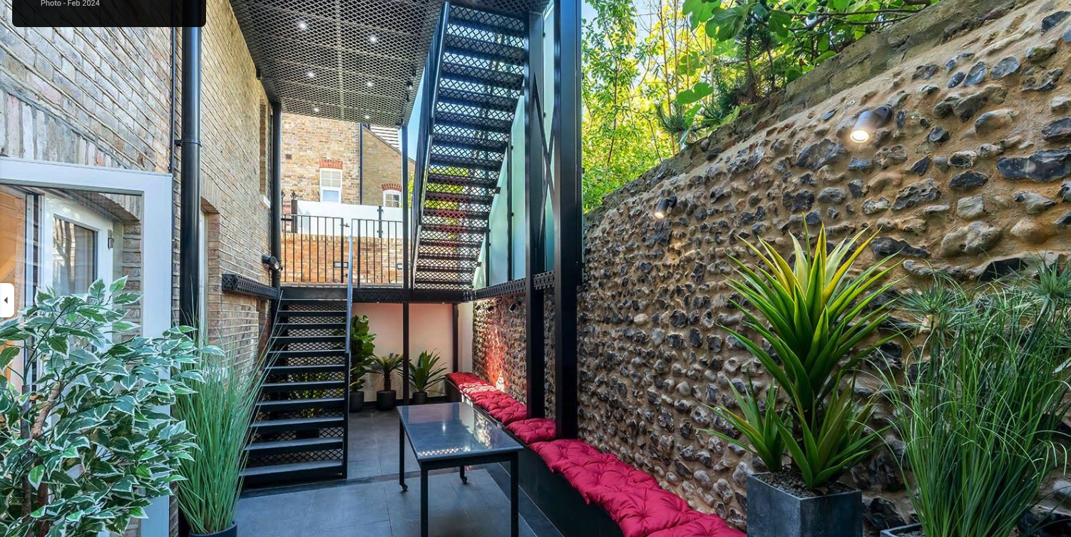 Modern extension with feature external staircase and stone wall garden